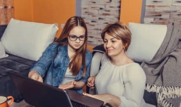 Mom and daughter looking at colleges on computer